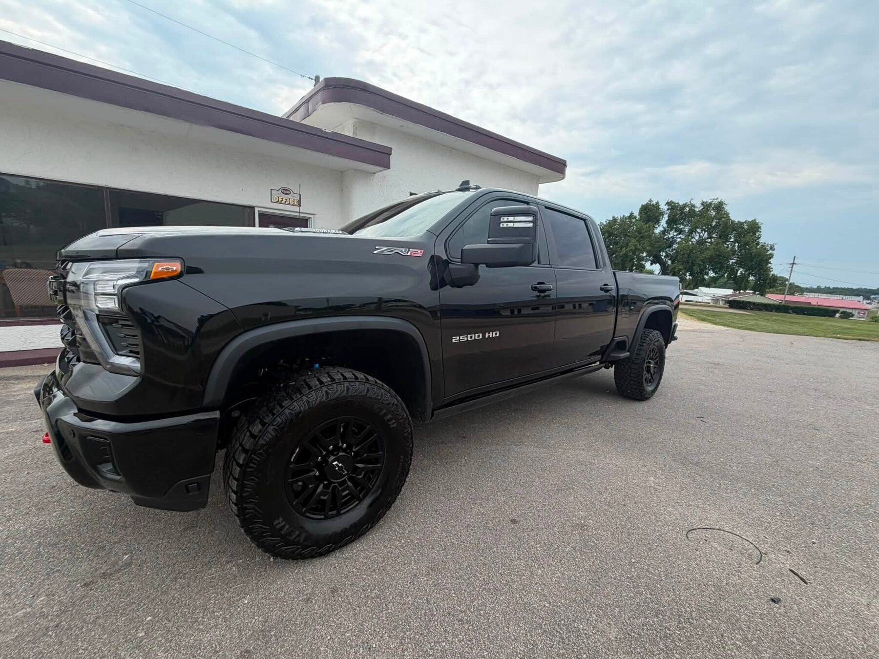 A gloss black Chevrolet Silverado 2500HD detailed by K & H outside their Eldon shop